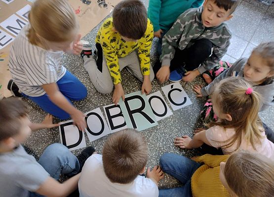 Uczniowie naklejają litery na krzyżówce