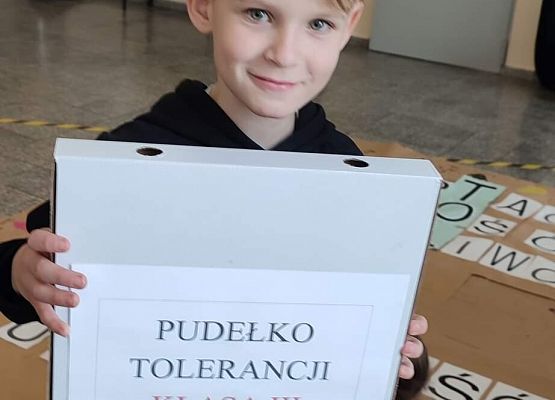 Chłopiec trzyma pudełko z napisem pudełko tolerancji klasa III