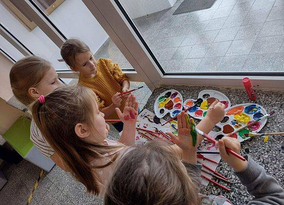 Dzieci malują dłonie farbami