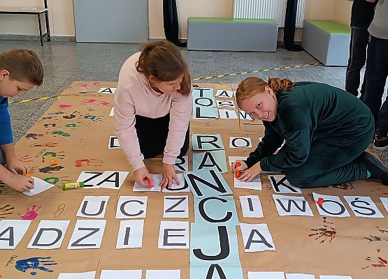 Dzieci przyklejają wyrazy w krzyżówce