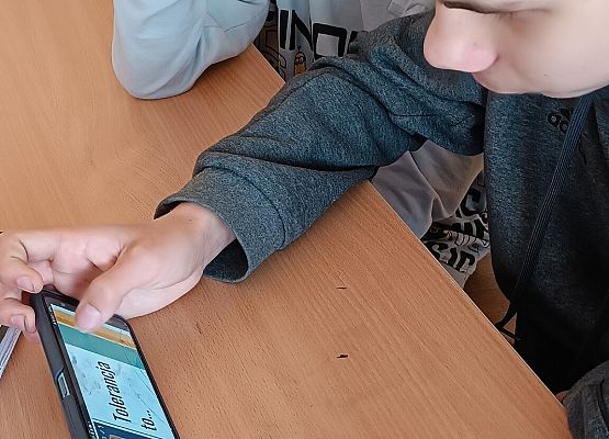 Uczniowie rozwiązują zadanie w telefonie
