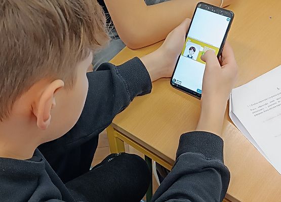 Uczniowie rozwiązują zadanie w telefonie