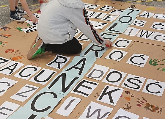 Uczniowie naklejają litery na krzyżówce