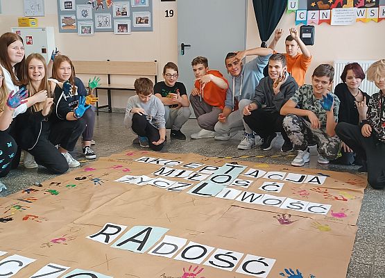 Uczniowie odciskają ślady dłoni na papierze