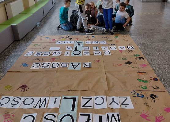 Uczniowie naklejają litery na krzyżówce