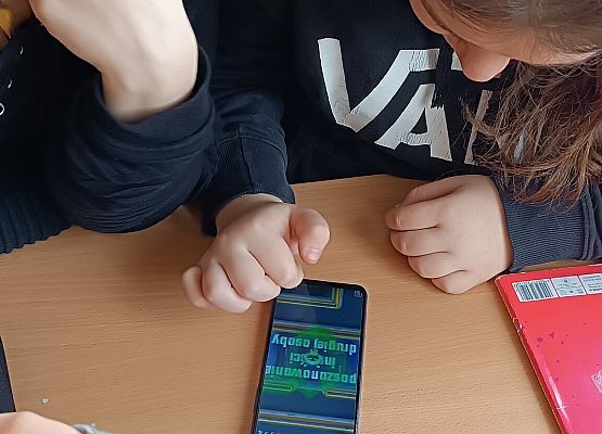 Uczniowie rozwiązują zadanie w telefonie