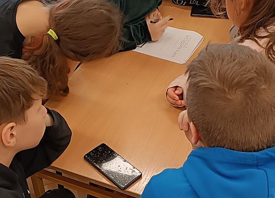 Uczniowie rozwiązują zadanie w telefonie
