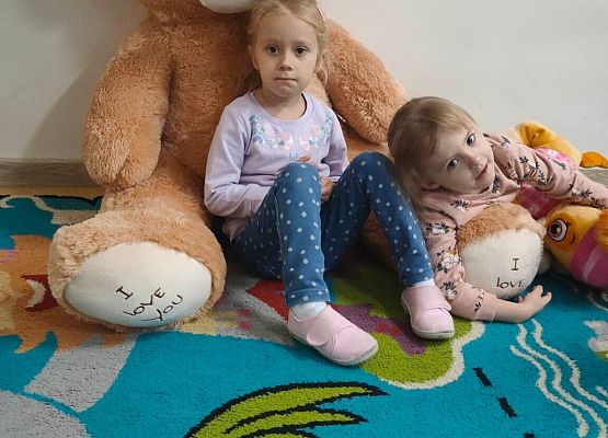 dwie dziewczynki odpoczywają z pluszowym miśkiem
