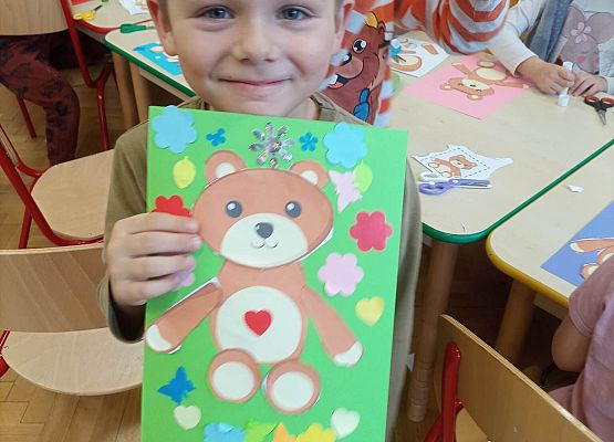 chłopiec prezentuje wykonaną pracę plastyczną o misiu