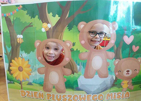 dzieci pozują do zdjęcia w makiecie z misiem