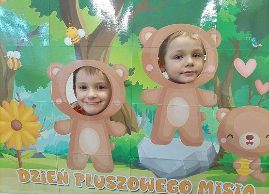 dzieci pozują do zdjęcia w makiecie z misiem