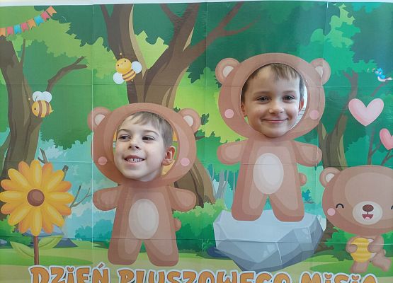 dzieci pozują do zdjęcia w makiecie z misiem