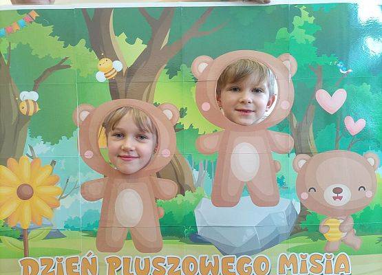 dzieci pozują do zdjęcia w makiecie z misiem