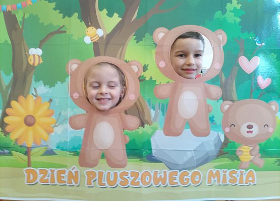 dzieci pozują do zdjęcia w makiecie z misiem