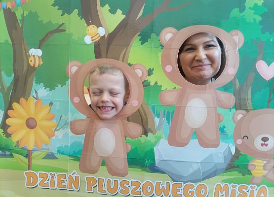 dzieci pozują do zdjęcia w makiecie z misiem