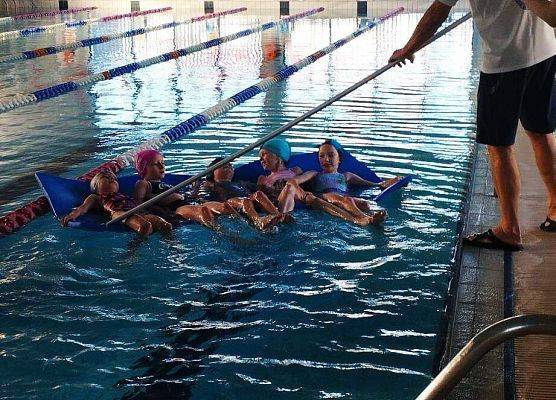 dzieci pływają na materacu