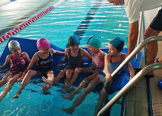 dzieci pływają na materacu