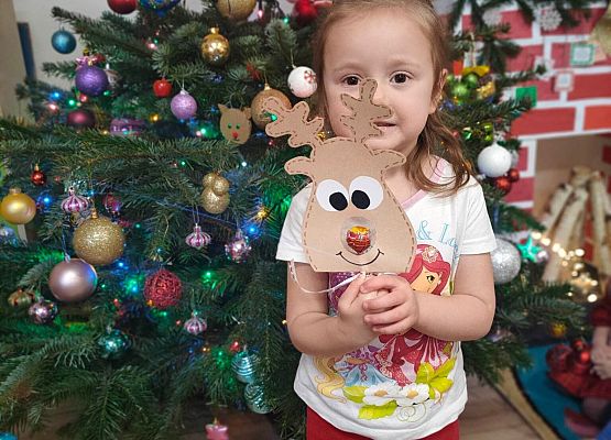 dziewczynka stoi przy choince