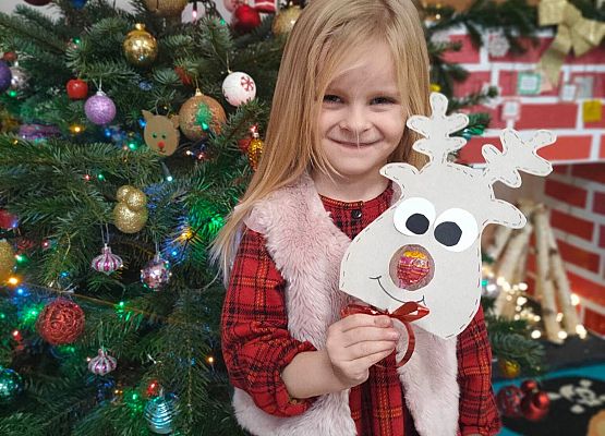 dziewczynka stoi przy choince