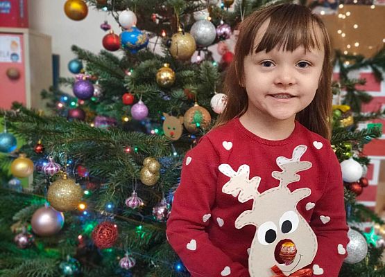 dziewczynka stoi przy choince