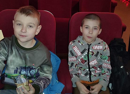 uczniowie siedzą na fotelach w kinie