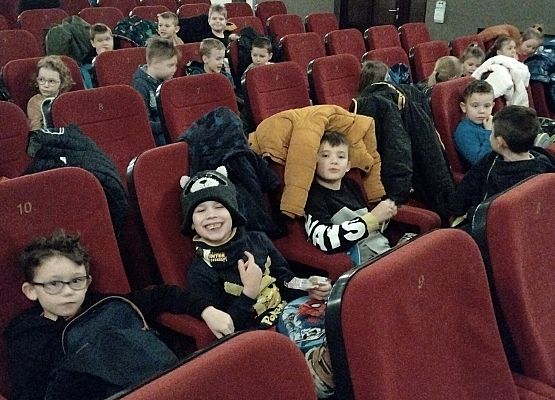 uczniowie siedzą na fotelach w kinie