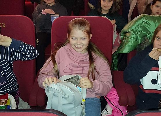 uczniowie siedzą na fotelach w kinie