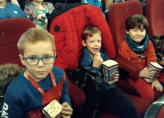 uczniowie siedzą na fotelach w kinie