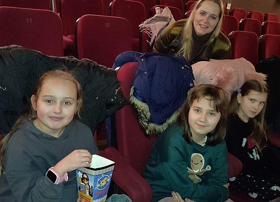 uczniowie siedzą na fotelach w kinie