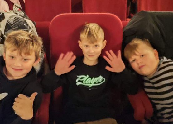 uczniowie siedzą na fotelach w kinie