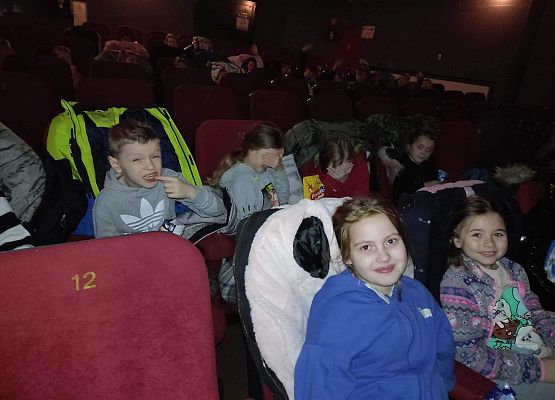 uczniowie siedzą na fotelach w kinie