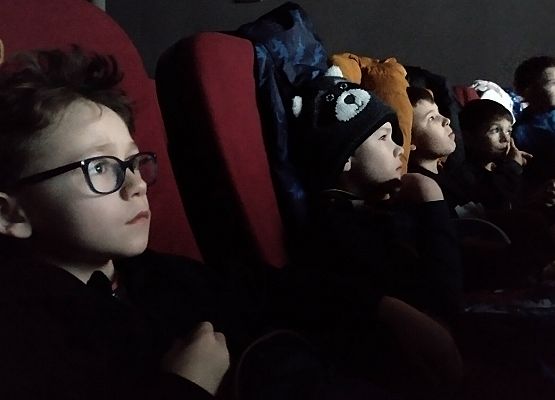 uczniowie siedzą na fotelach w kinie