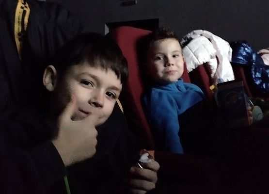 uczniowie siedzą na fotelach w kinie