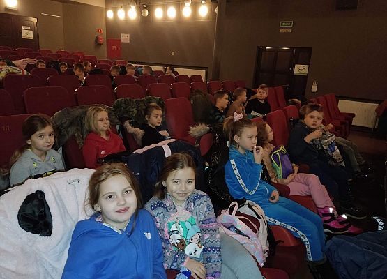 uczniowie siedzą na fotelach w kinie