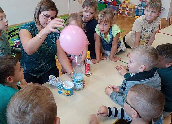 nauczycielka prezentuje dzieciom doświadczenie rosnące balony