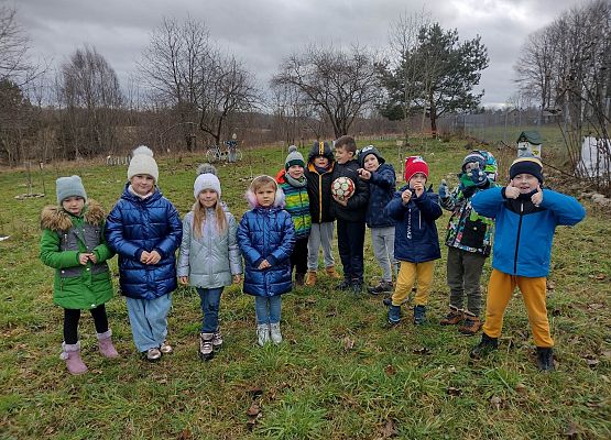 Uczniowie stoją w szkolnym sadzie - zdjęcie grupowe