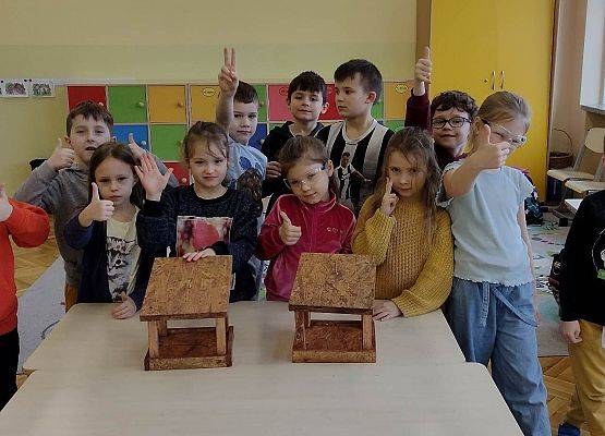 uczniowie prezentują zrobione przez siebie karmniki dla ptaków