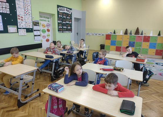 uczniowie siedzą w ławkach