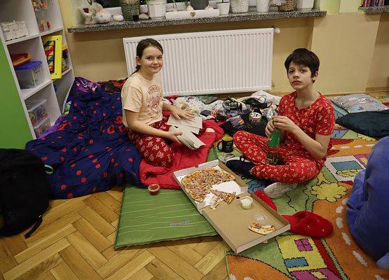 uczniowie jedzą pizzę