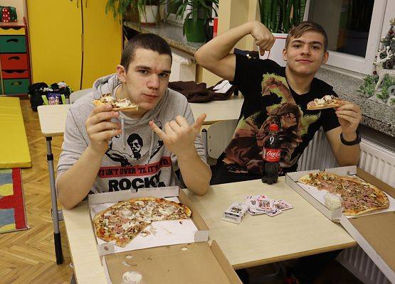 uczniowie jedzą pizzę