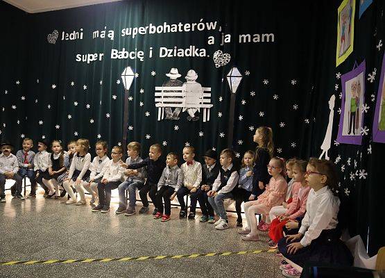 dzieci siedzą na ławeczce na scenie