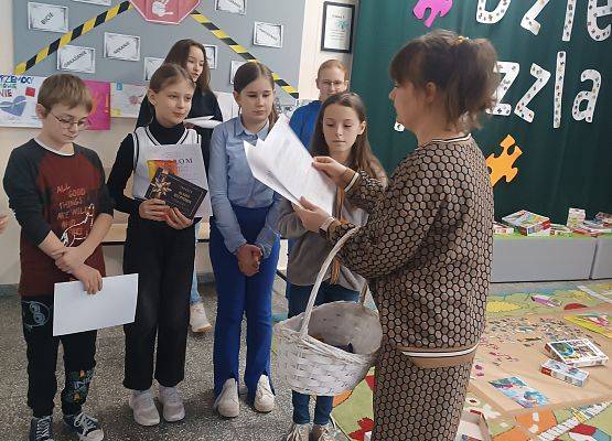 Nauczycielka wręcza dyplomy uczniom