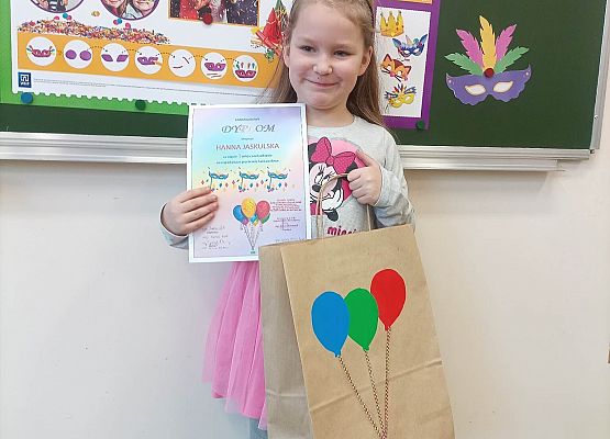 dziewczynka prezentuje otrzymany dyplom