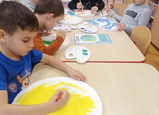 dzieci malują farbami planety