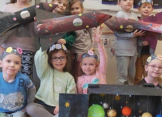 dzieci trzymają makiety rakiet kosmicznych