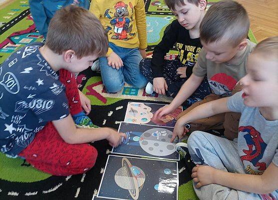 dzieci układają karty z planetami