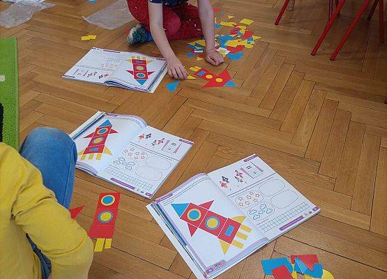 dzieci układają rakiety z figur geometrycznych