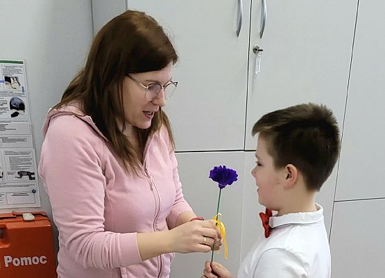 chłopiec wręcza pani kwiatka