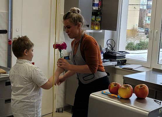 chłopiec wręcza pani kwiatka