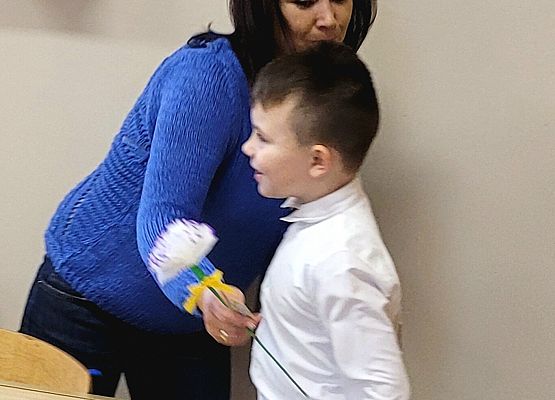 chłopiec wręcza kwiatka pani